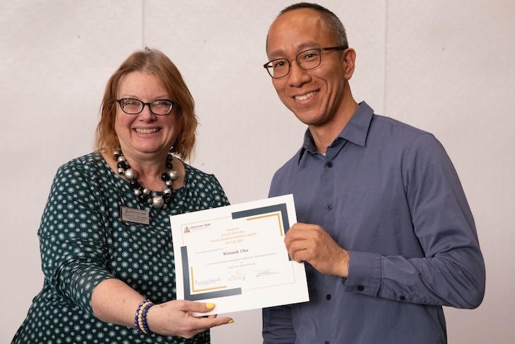 Two people holding a certificate